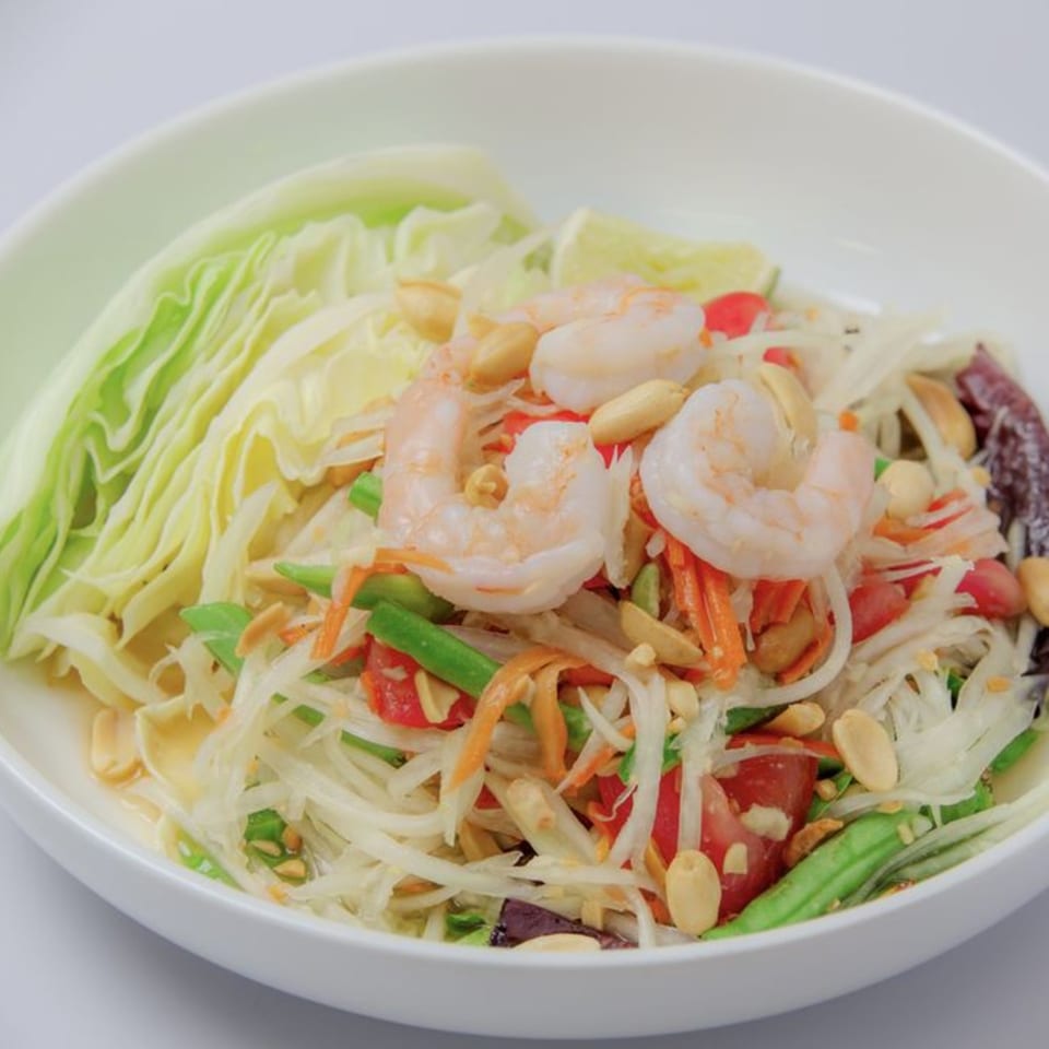Som Tum, a Thai papaya salad with shrimp, peanuts, green beans, tomatoes, and cabbage.
